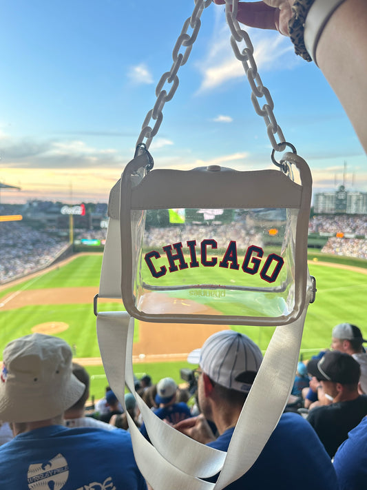 Chicago white clear crossbody bag with red and blue CHICAGO lettering overlooking a baseball field