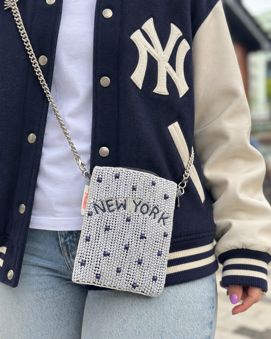 NEW YORK white and navy dot beaded cell phone crossbody styled with navy varsity jacket