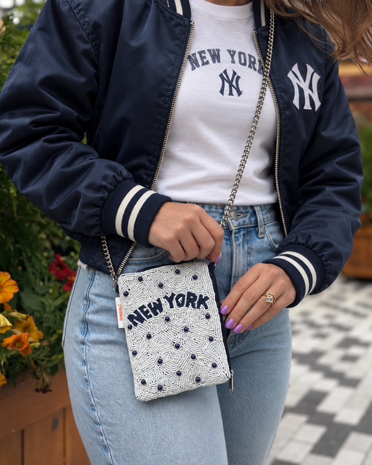 NEW YORK white and navy beaded cell phone crossbody styled with navy bomber jacket