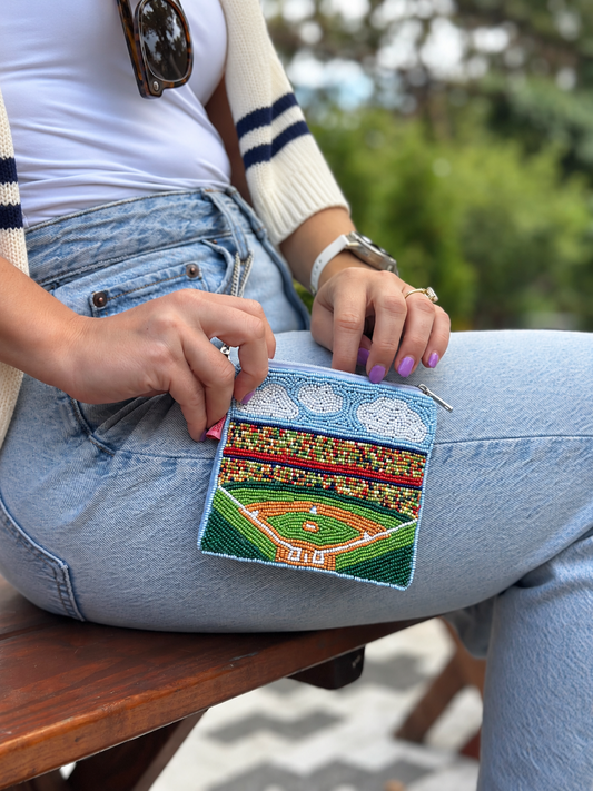 Baseball Stadium beaded coin purse held on lap with cream cardigan