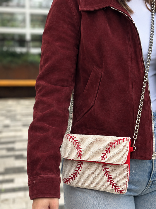 White and red baseball stitch beaded clutch styled with burgundy jacket