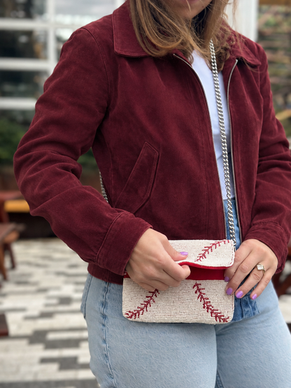 White and red baseball stitch beaded clutch with flap partially open