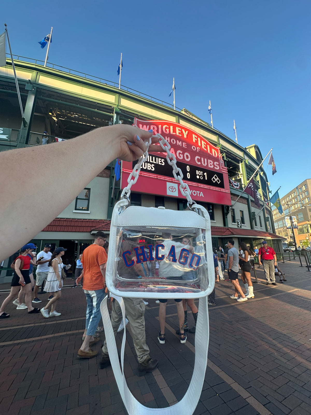Chicago white clear crossbody bag with red and blue CHICAGO lettering outside a ballpark