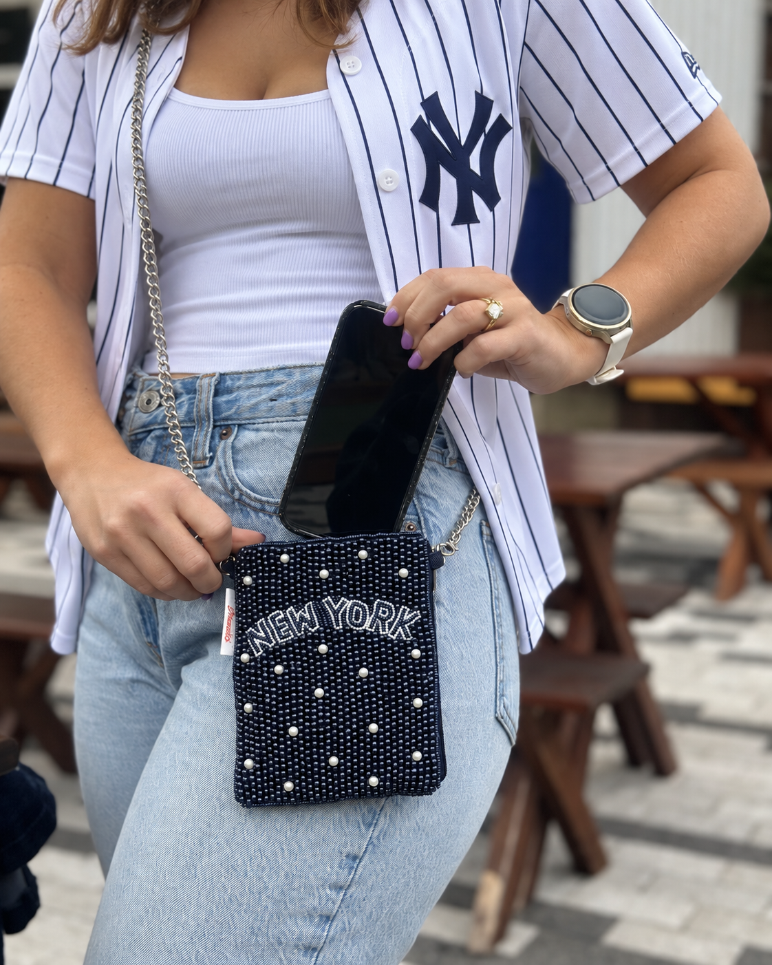 NEW YORK navy beaded cell phone crossbody holding a phone