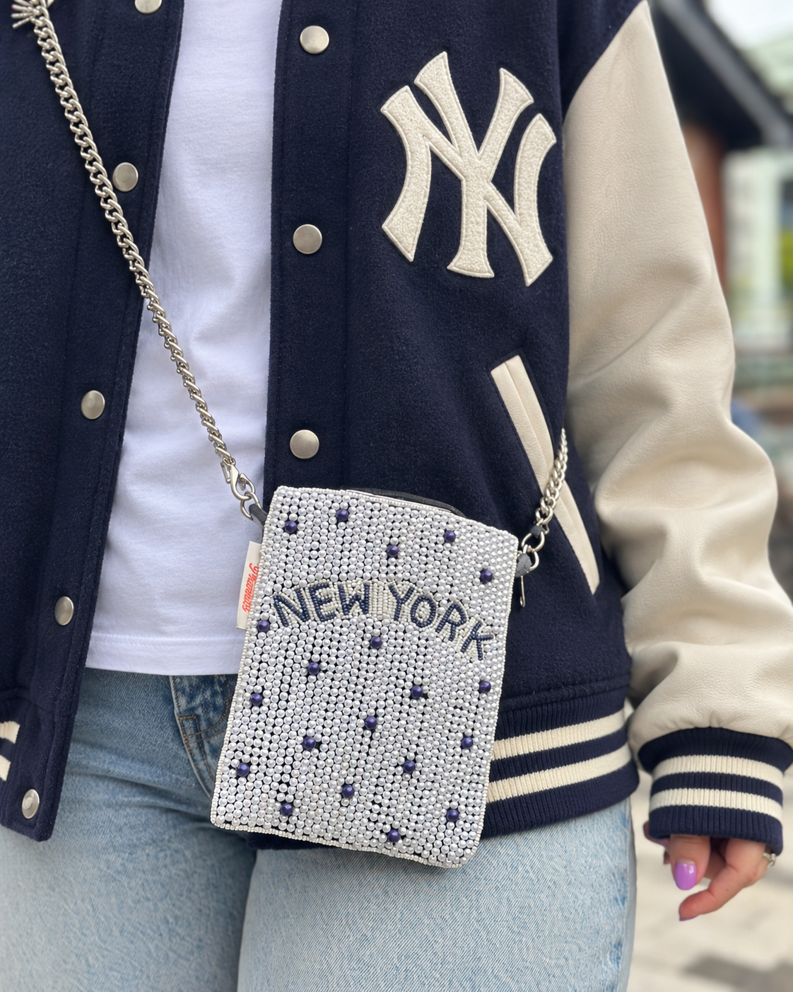 NEW YORK white and navy dot beaded cell phone crossbody styled with navy varsity jacket