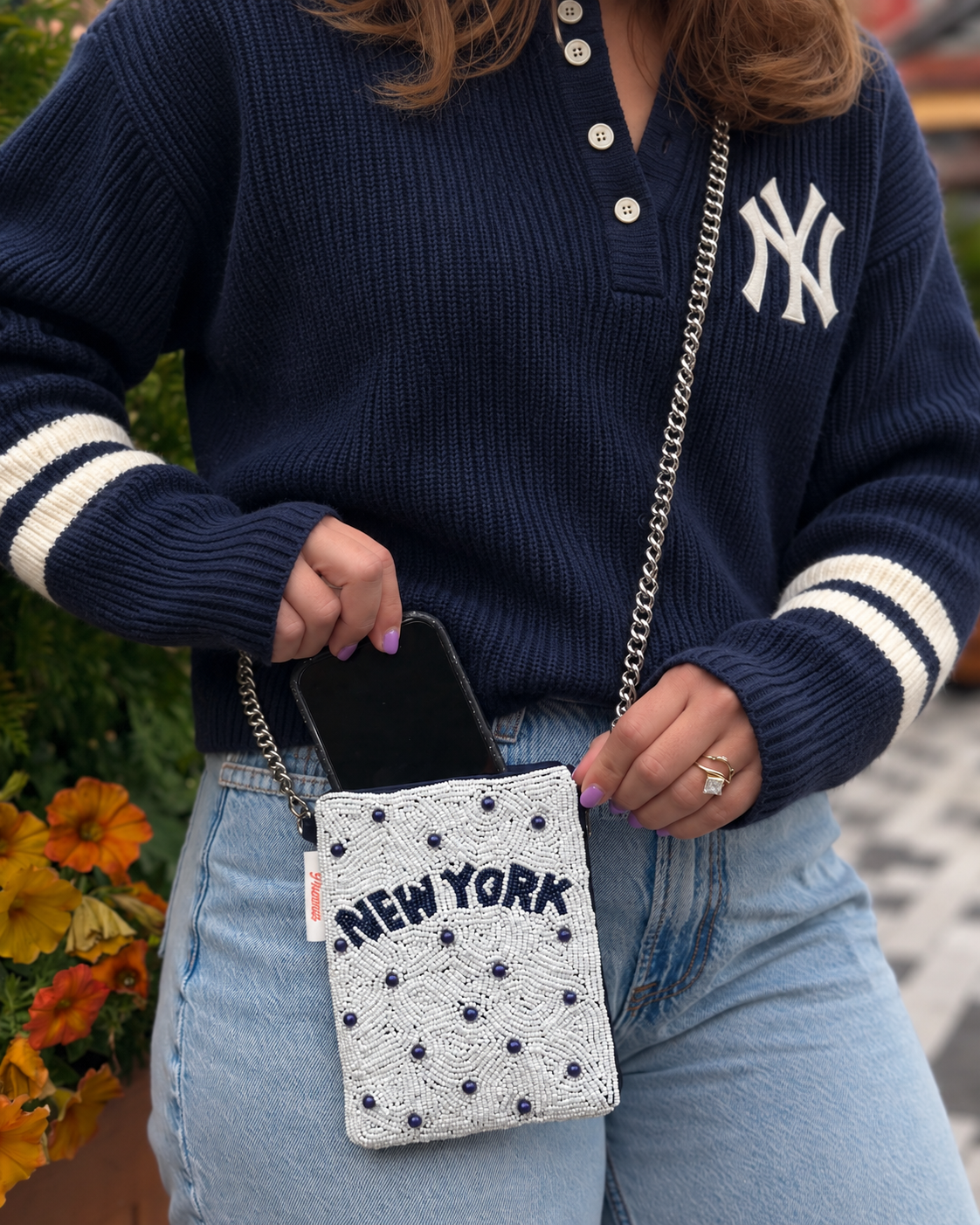 NEW YORK white and navy beaded cell phone crossbody styled with navy knit sweater