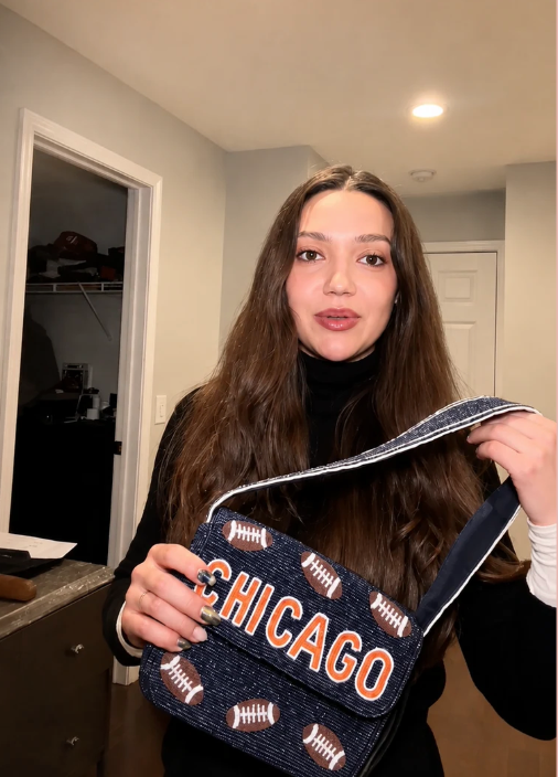 Customer holding Chicago football beaded bag, CHICAGO text facing forward