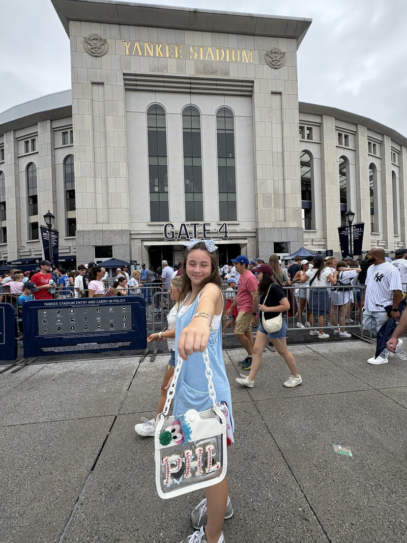 Fan holding clear PHL purse outside Yankee Stadium Gate 4
