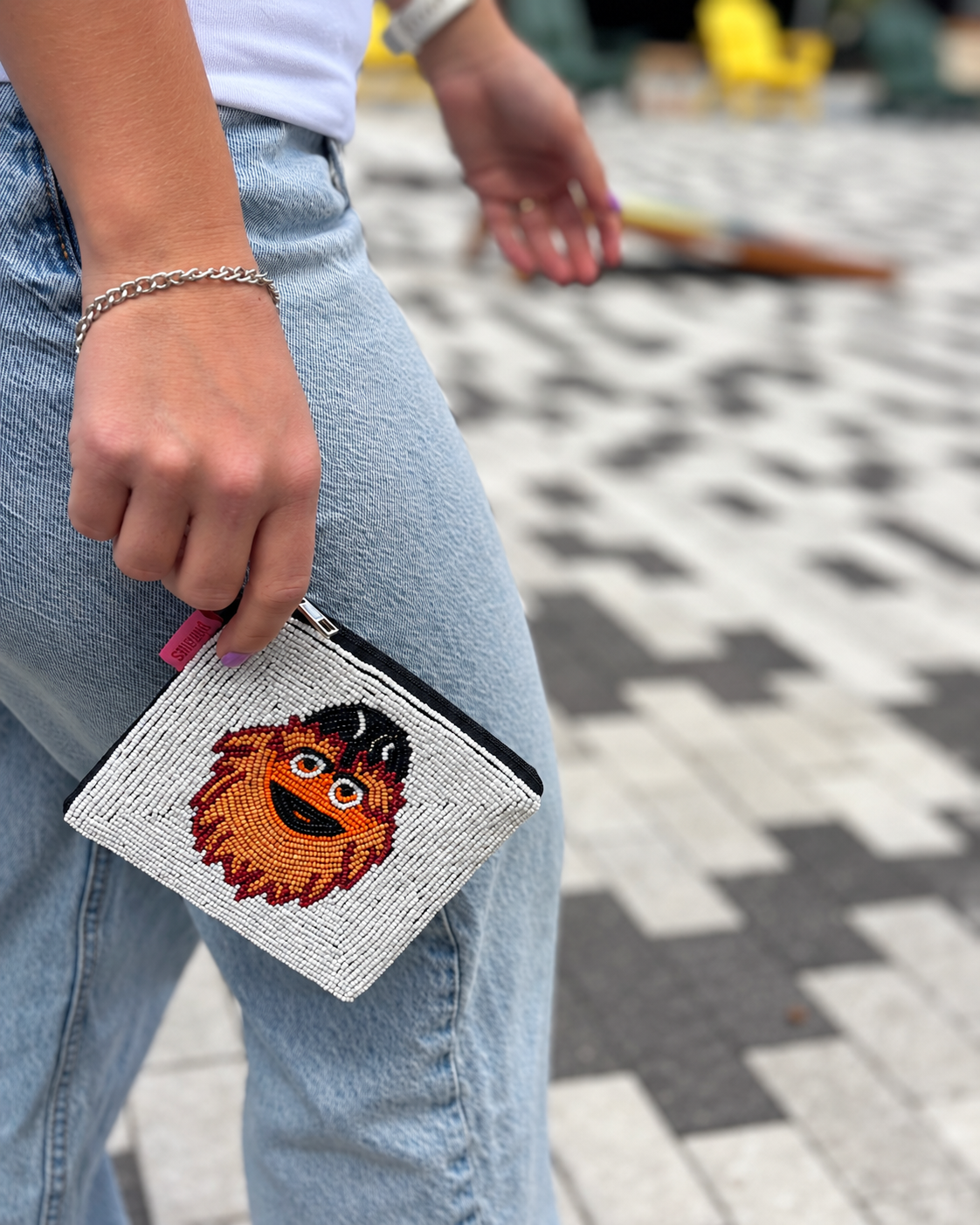 Philadelphia hockey mascot beaded coin purse held with jeans